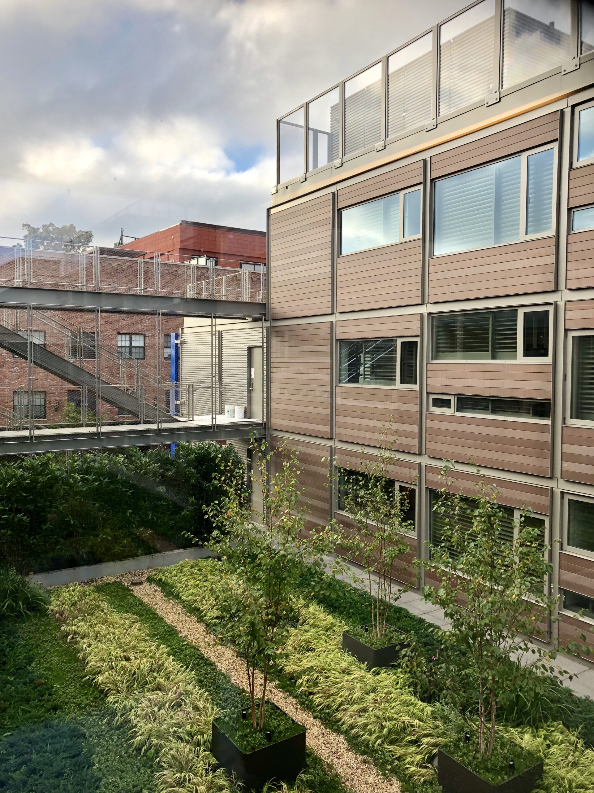 Interior courtyard of modular Pod Hotel in New York with green landscaping and rooms to the right