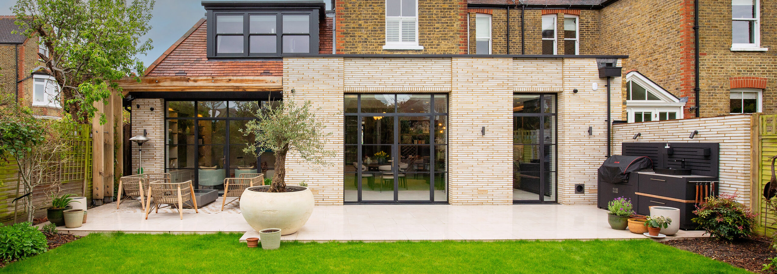 View of residential rear extension in light brick and patio french doors