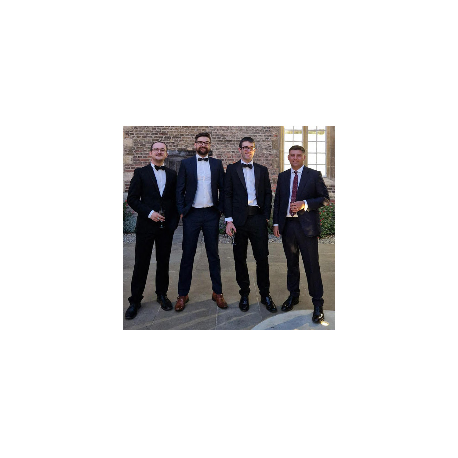 Four male engineers in black tie standing outside Jesus College for the CFCI Next Gen events 2024