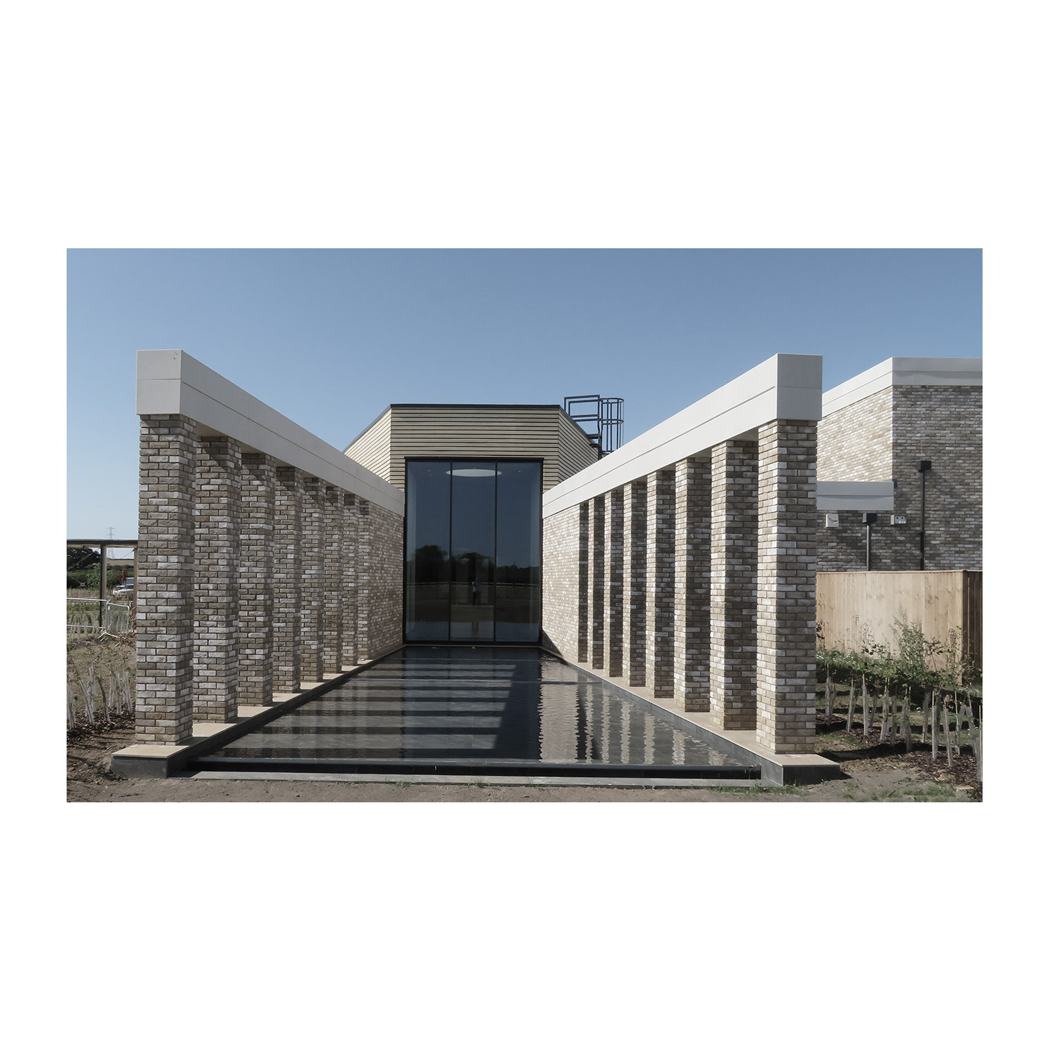 Oakfield Gardens New Crematorium with water channel leading down to the chapel under a blue sky