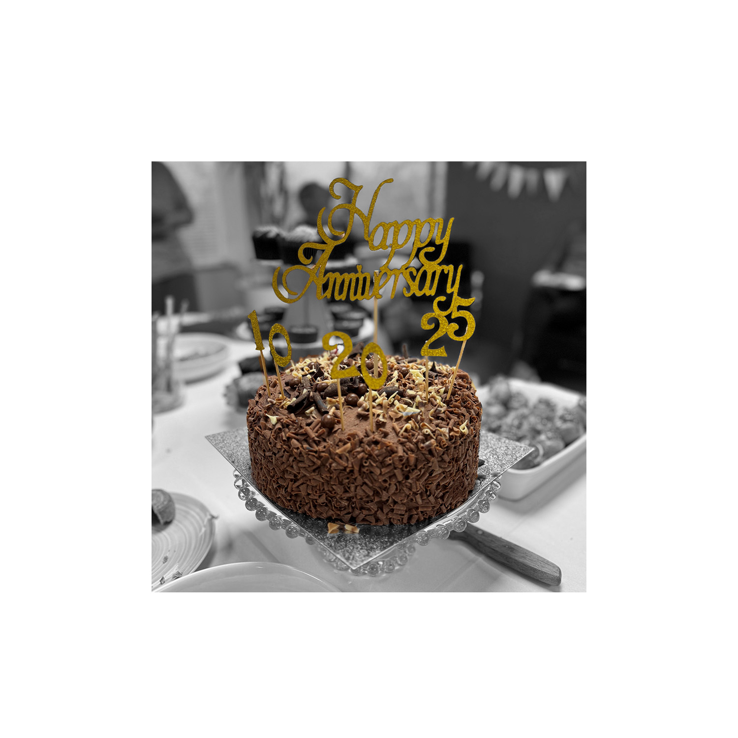 Chocolate cake with golden happy anniversary decoration lettering