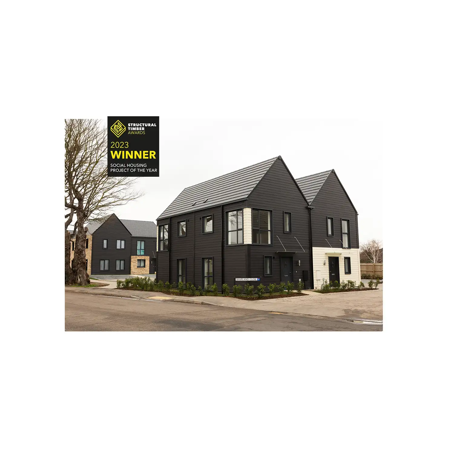 black and white wood panel housing with gable roofs on new estate