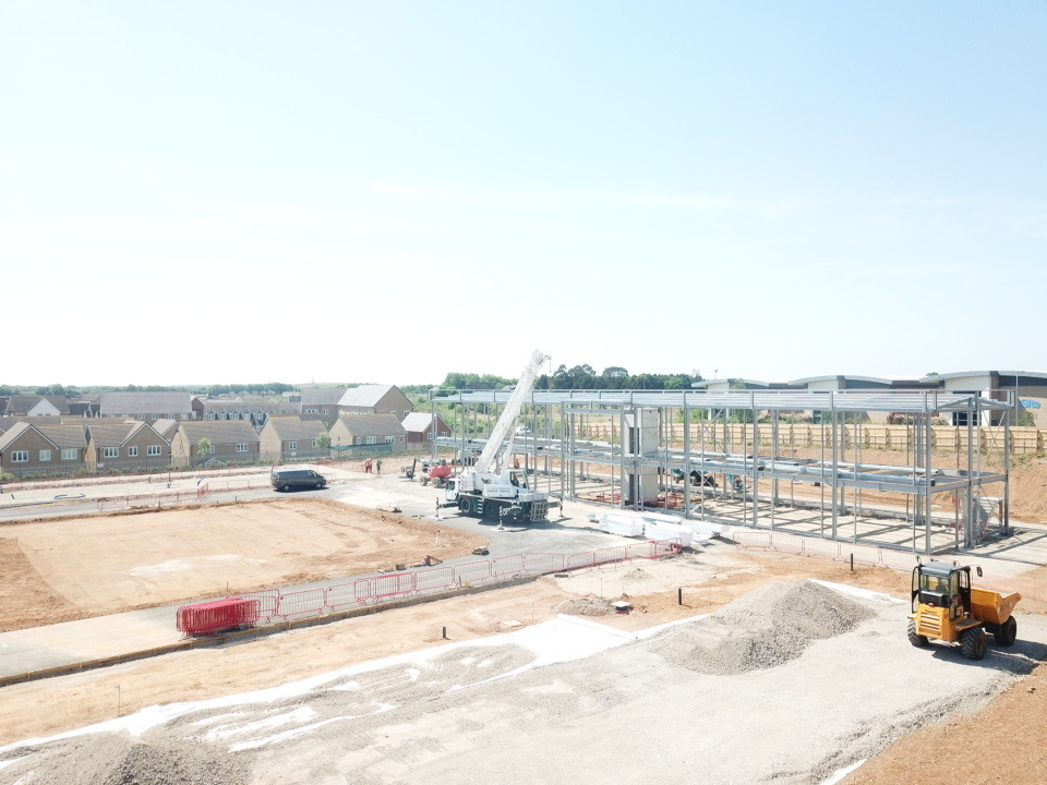 Construction site for a new housing development with crane and steel frame going up