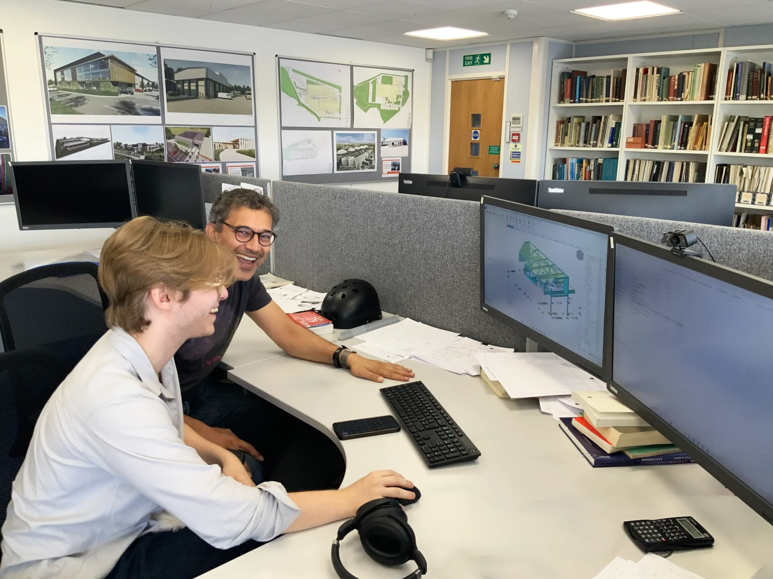 Summer engineering intern at desk with his mentor in an office