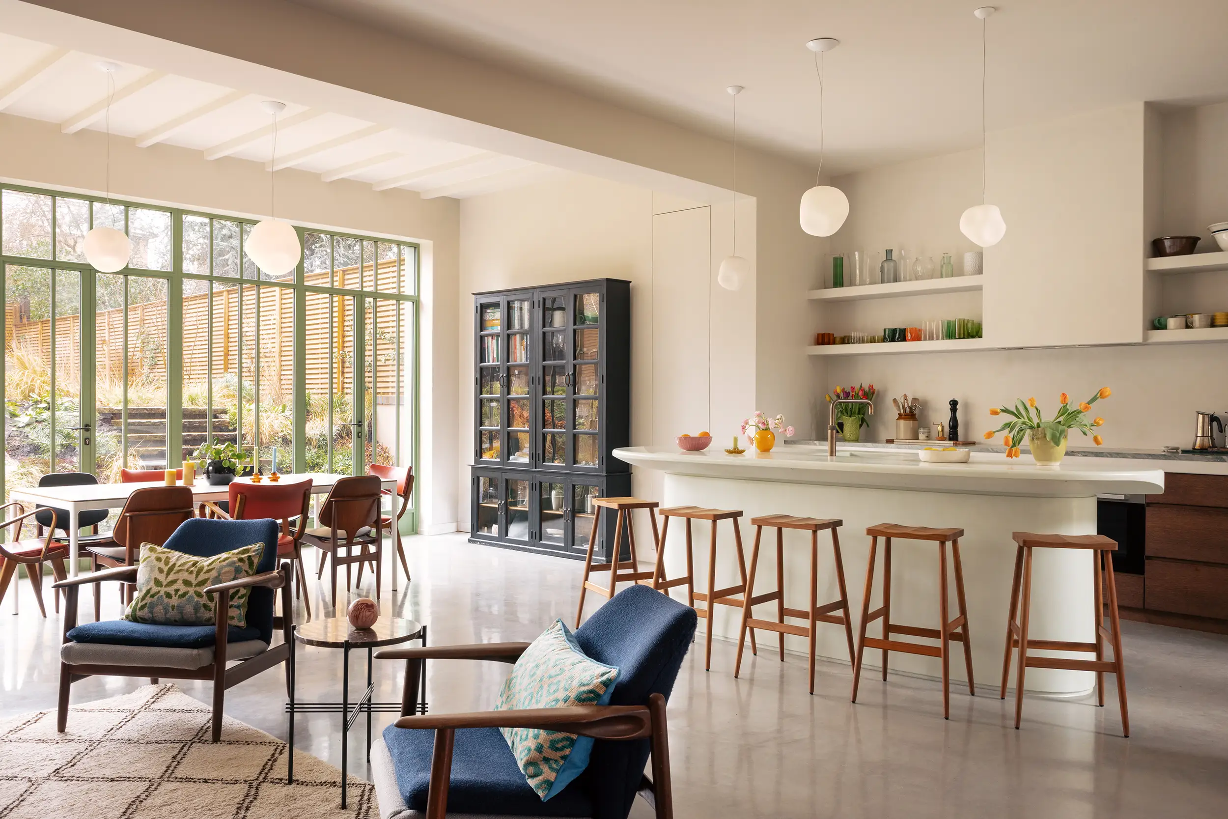 Interior view of the Grosvenor Road House extension with white walls and green framed sliding doors and windows